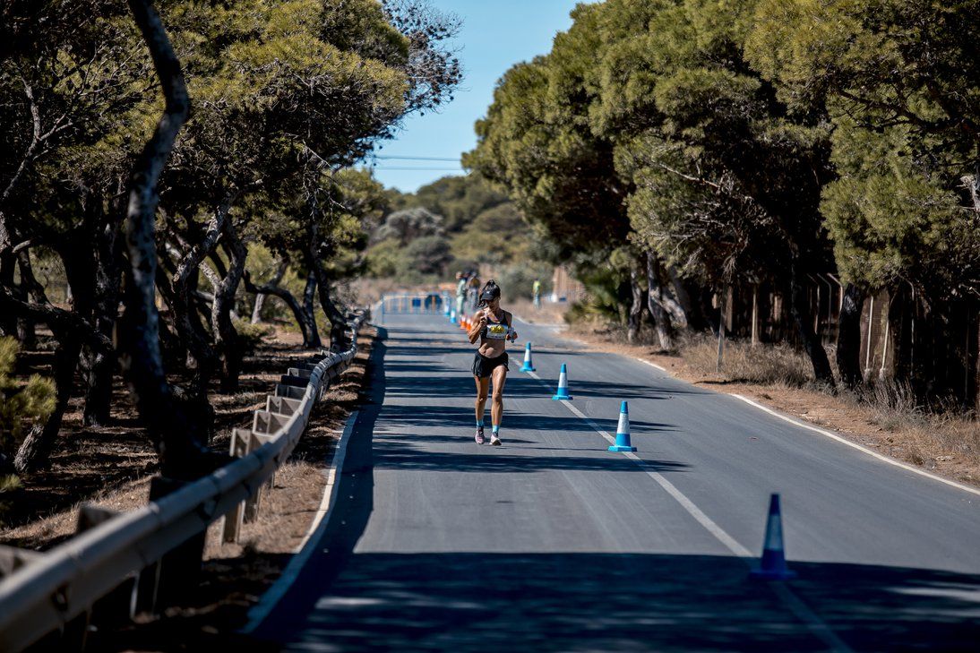 Corredores por una carretera entre pinos