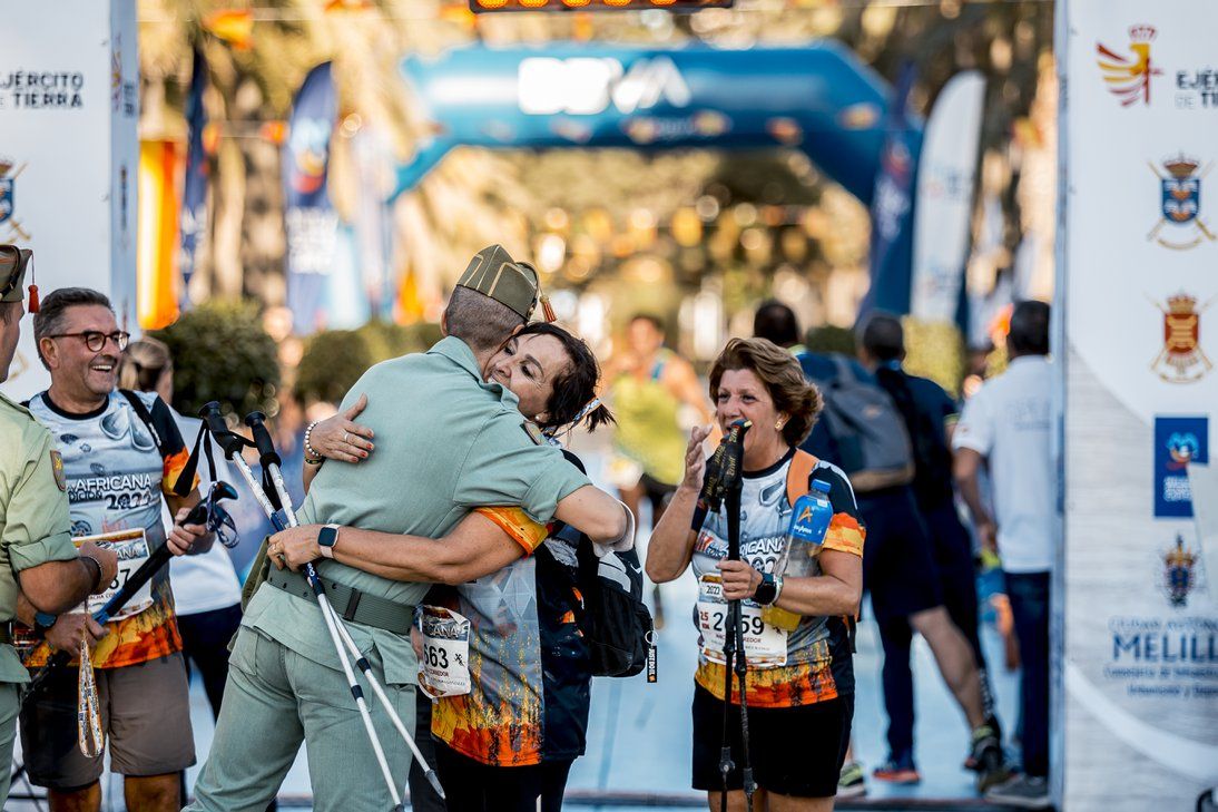 Un legionario abraza a una participante en la meta