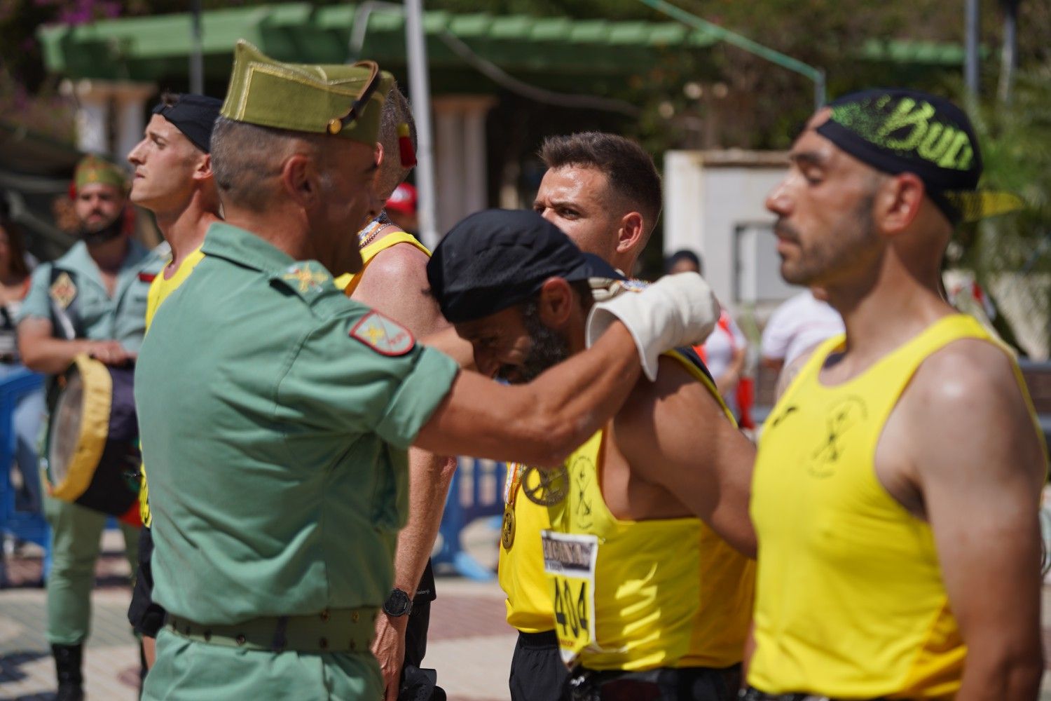 Un legionario impone la medalla a un participante