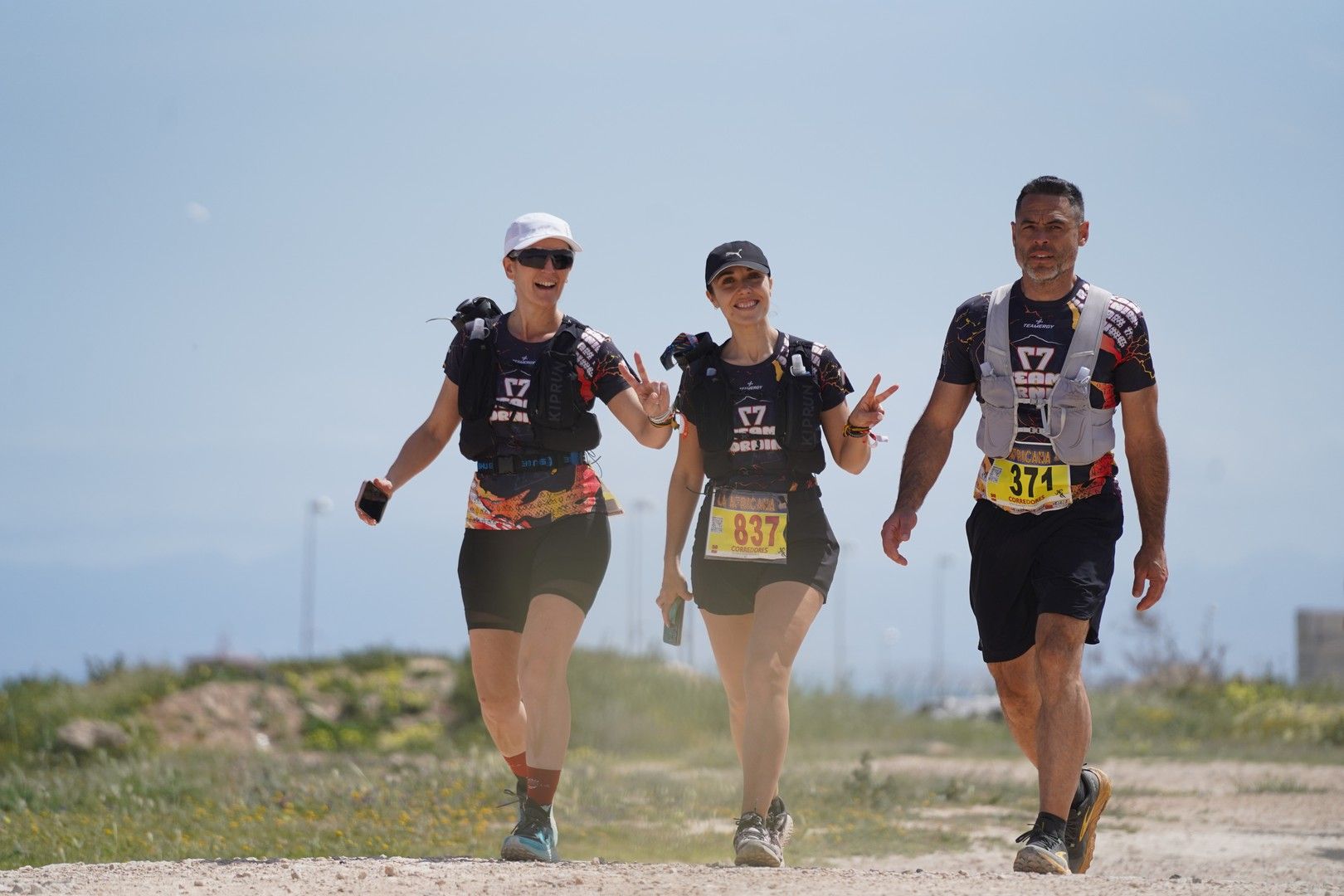 Tres corredores avanzan juntos por un camino