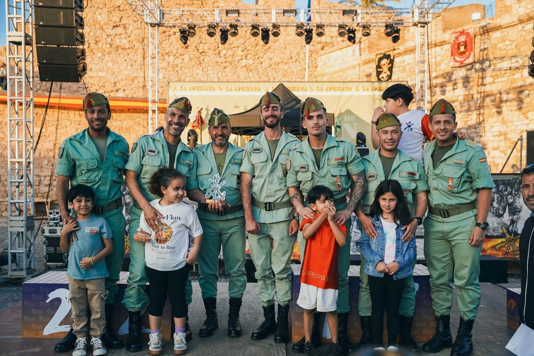 Legionarios posan con niños de la Miniafricana en el escenario de meta