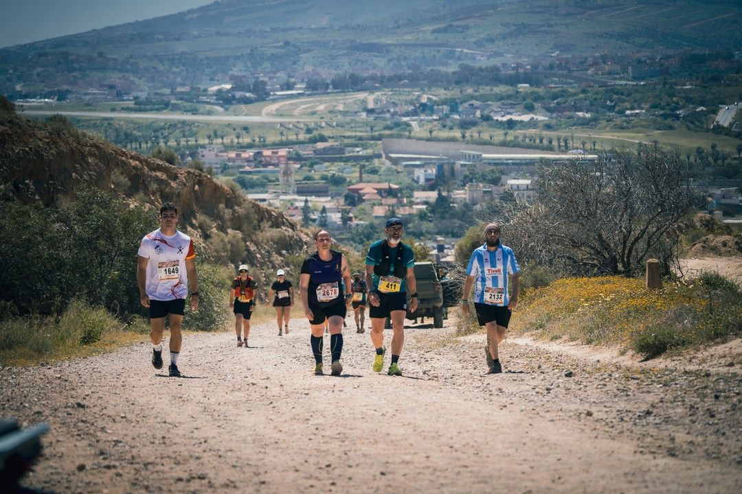 Grupo de marchadores por un camino de tierra con vistas a la ciudad
