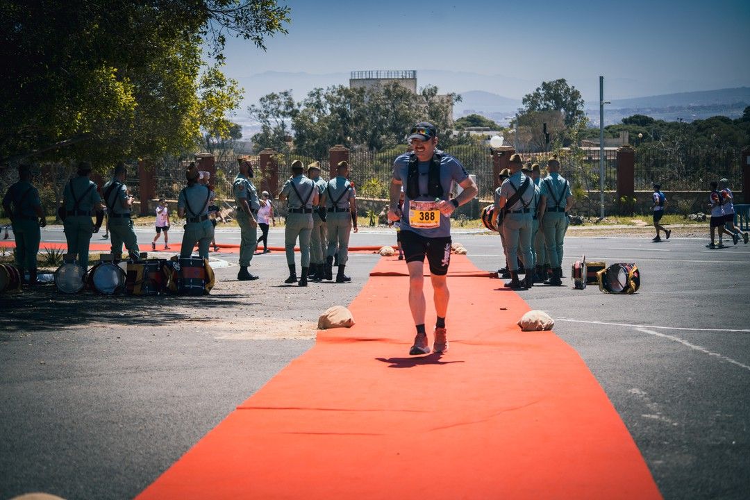 Un corredor llega por la alfombra roja entre dos filas de legionarios