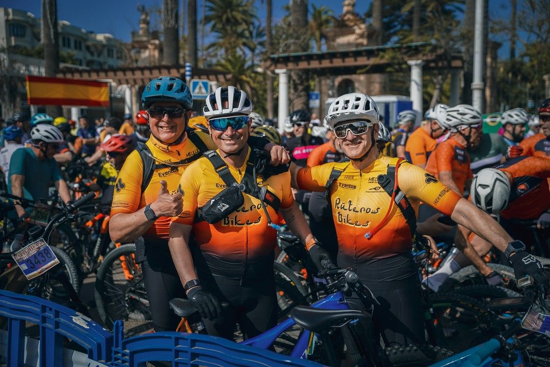 Grupo de ciclistas de BTT sonrientes en la parrilla de salida