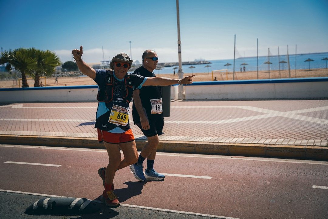 Dos corredores saludan a la cámara en el paseo marítimo