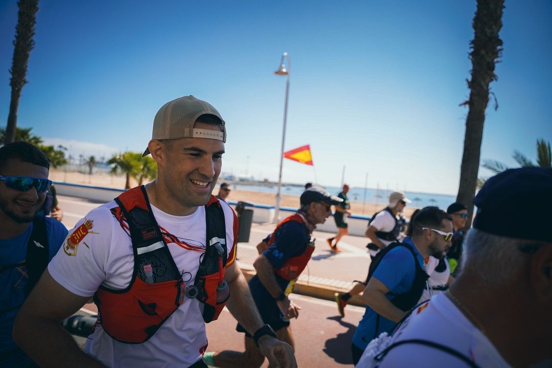 Un corredor sonríe en el paseo marítimo con una bandera de España al fondo