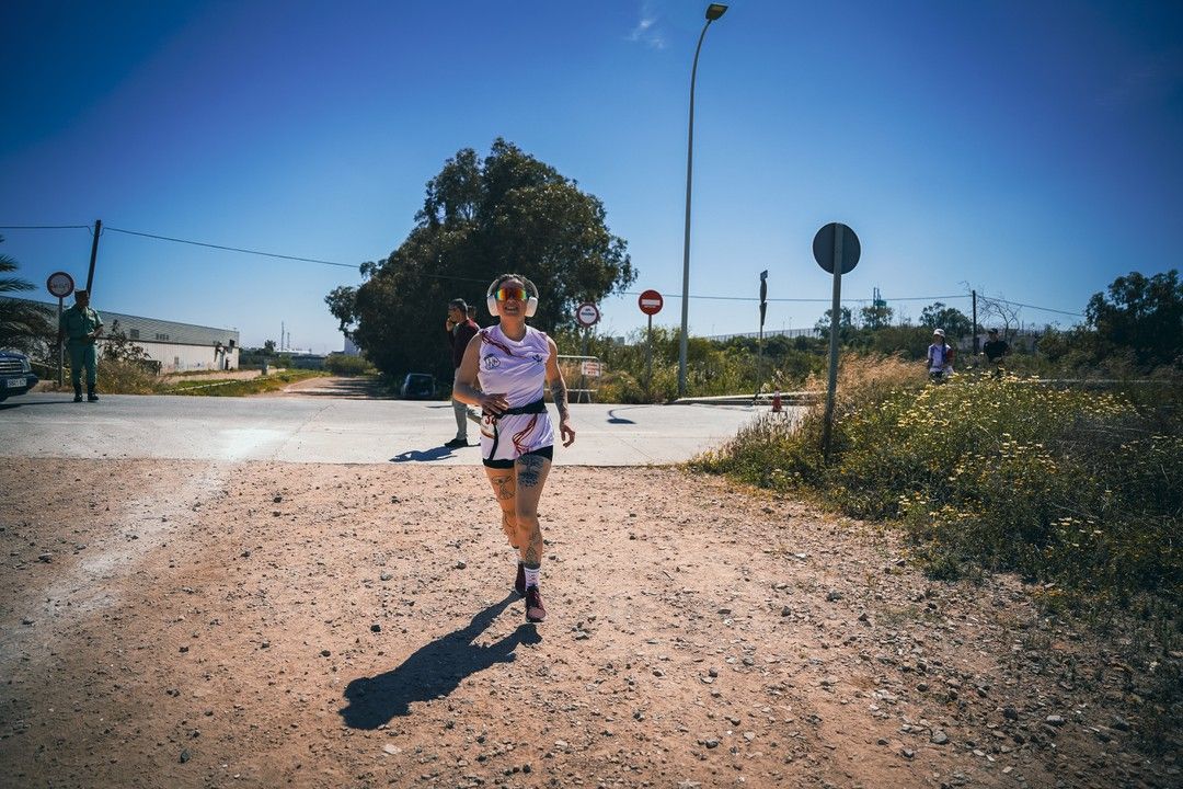 Una marchadora avanza en solitario por un camino de tierra